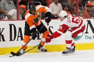 Defenseman Danny DeKeyser (#65) of the Detroit Red Wings reaches to block a pass by Right Wing Wayne Simmonds (#17) of the Philadelphia Flyers