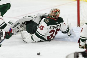 Goalie Darcy Kuemper (#35) of the Minnesota Wild rolls on his back to stop the puck