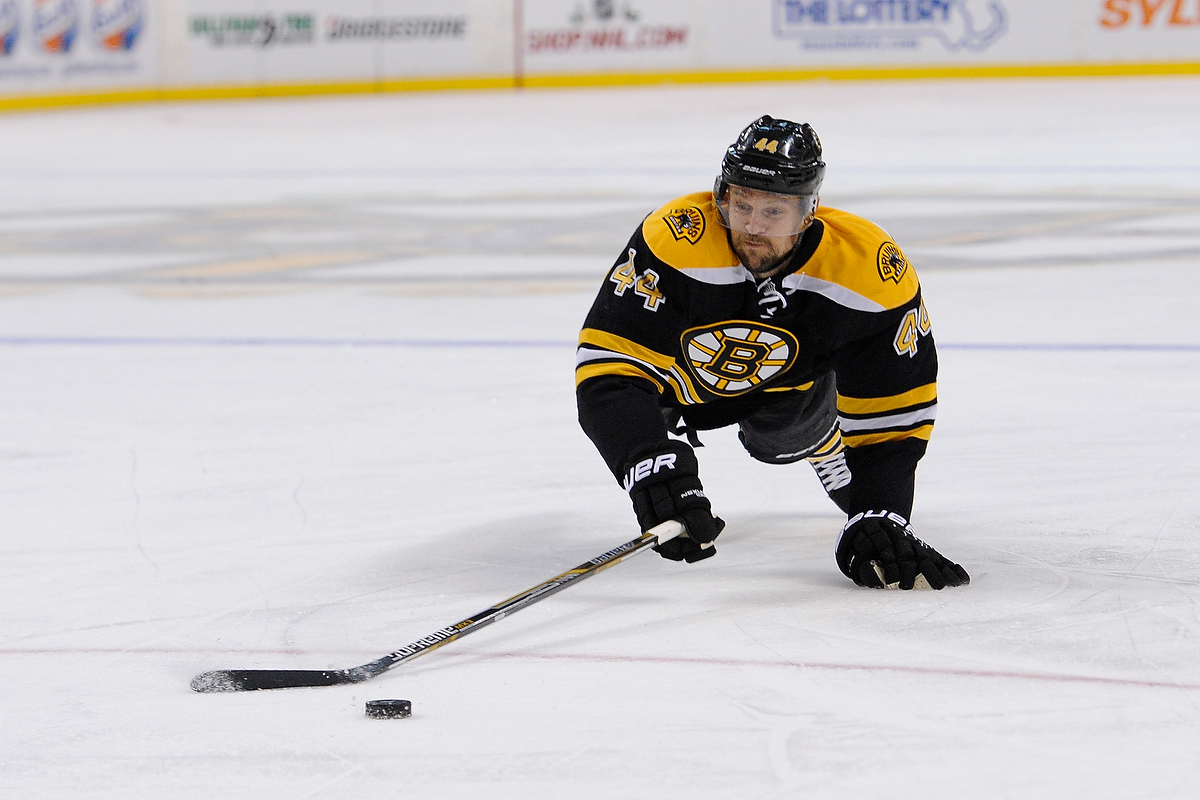 Boston Bruins defenseman Dennis Seidenberg (44) dives for the puck.