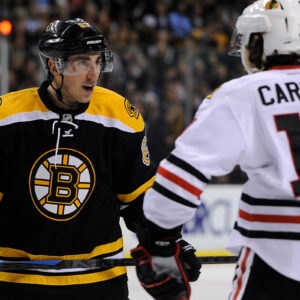Chicago Blackhawks left wing Daniel Carcillo (13) and Boston Bruins left wing Brad Marchand (63) exchange words before a face-off.