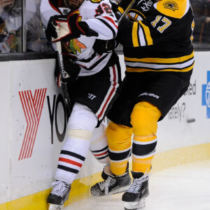 Boston Bruins left wing Milan Lucic (17) hits Chicago Blackhawks defenseman Michal Rozsival (32).