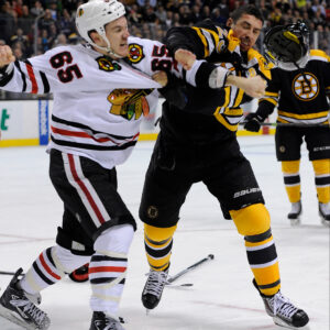 Boston Bruins center Chris Kelly (23) and Chicago Blackhawks center Andrew Shaw (65) fight during the third period.