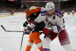 Defenseman Dan Girardi (#5) of the New York Rangers and Left Wing R.J. Umberger (#18) of the Philadelphia Flyers battle for the puck