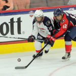 Sean Dhooghe (#10 - White) and Mick Messner (#12 - Blue) battle for the puck
