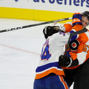 Right Wing Travis St. Denis (#74) of the New York Islanders gets his glove in the face of Defenseman Travis Sanheim (#57) of the Philadelphia Flyers