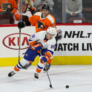 Defenseman Sebastian Aho (#28) of the New York Islanders plays the puck away from Left Wing Isaac Ratcliffe (#76) of the Philadelphia Flyers