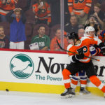 Center Nolan Patrick (#64) of the Philadelphia Flyers and Center Scott Eansor (#36) of the New York Islanders collide along the boards